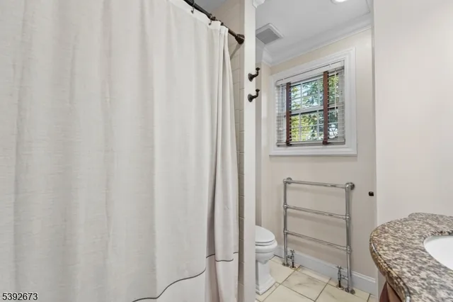 a bathroom with a granite countertop sink and a window