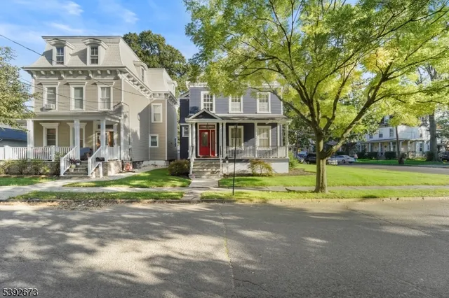 a view of a house with a big yard and palm trees