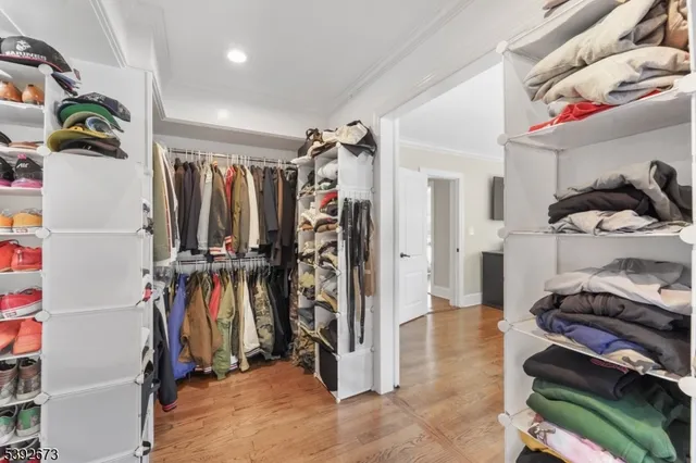 a view of walk in closet with clothes and shoes