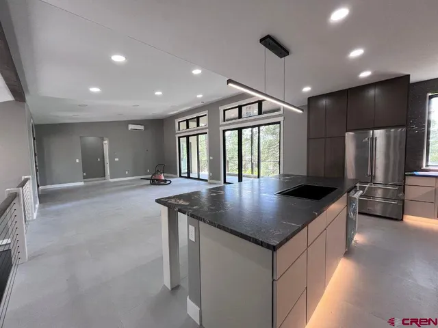 a kitchen with stainless steel appliances granite countertop a sink a stove and a refrigerator