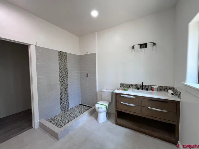 an empty room with window and ceiling fan