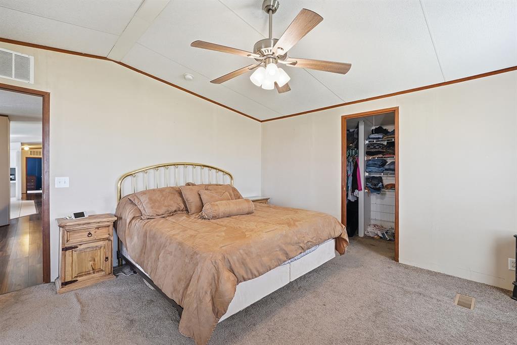 2538 County Road 2320 Decatur, TX 76234 - Photo 17 of 40 a bedroom with a bed and a chandelier
