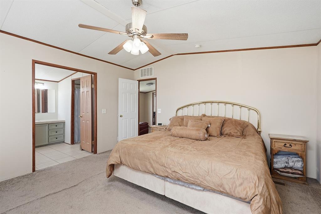2538 County Road 2320 Decatur, TX 76234 - Photo 18 of 40 a bedroom with a large bed and chandelier