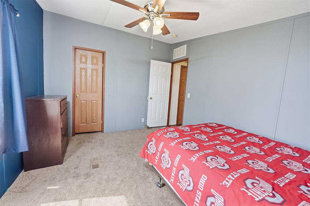 2538 County Road 2320 Decatur, TX 76234 - Photo 24 of 40 a bedroom with a bed and a chandelier