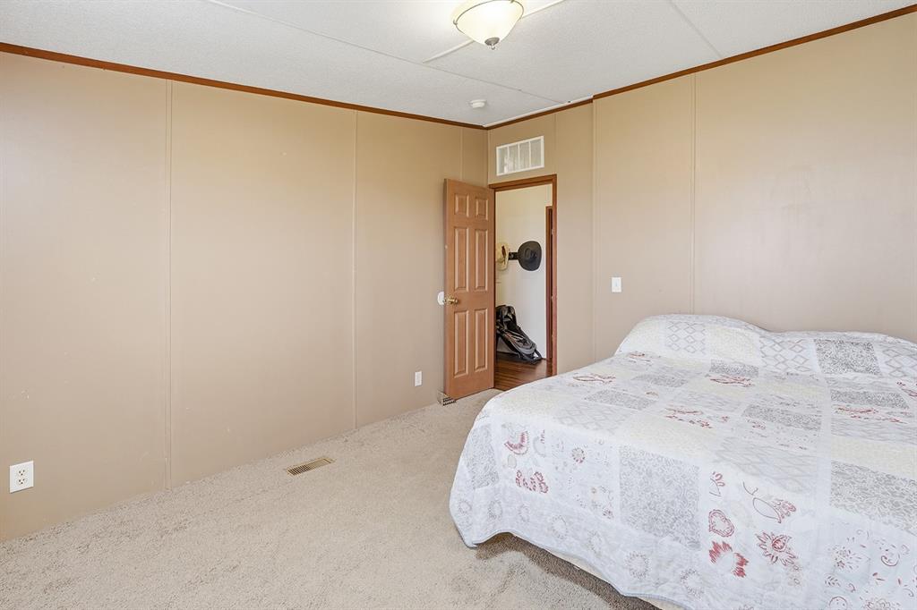 2538 County Road 2320 Decatur, TX 76234 - Photo 29 of 40 a bedroom with a bed and a chandelier fan
