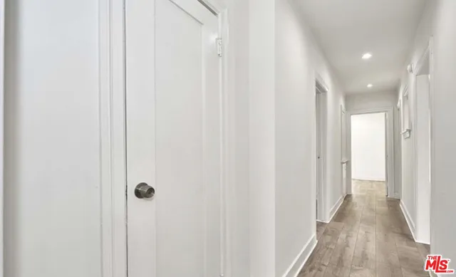 a view of a hallway with wooden floor