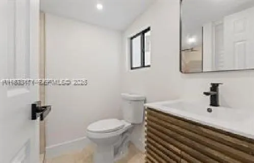 a bathroom with a sink a toilet and mirror
