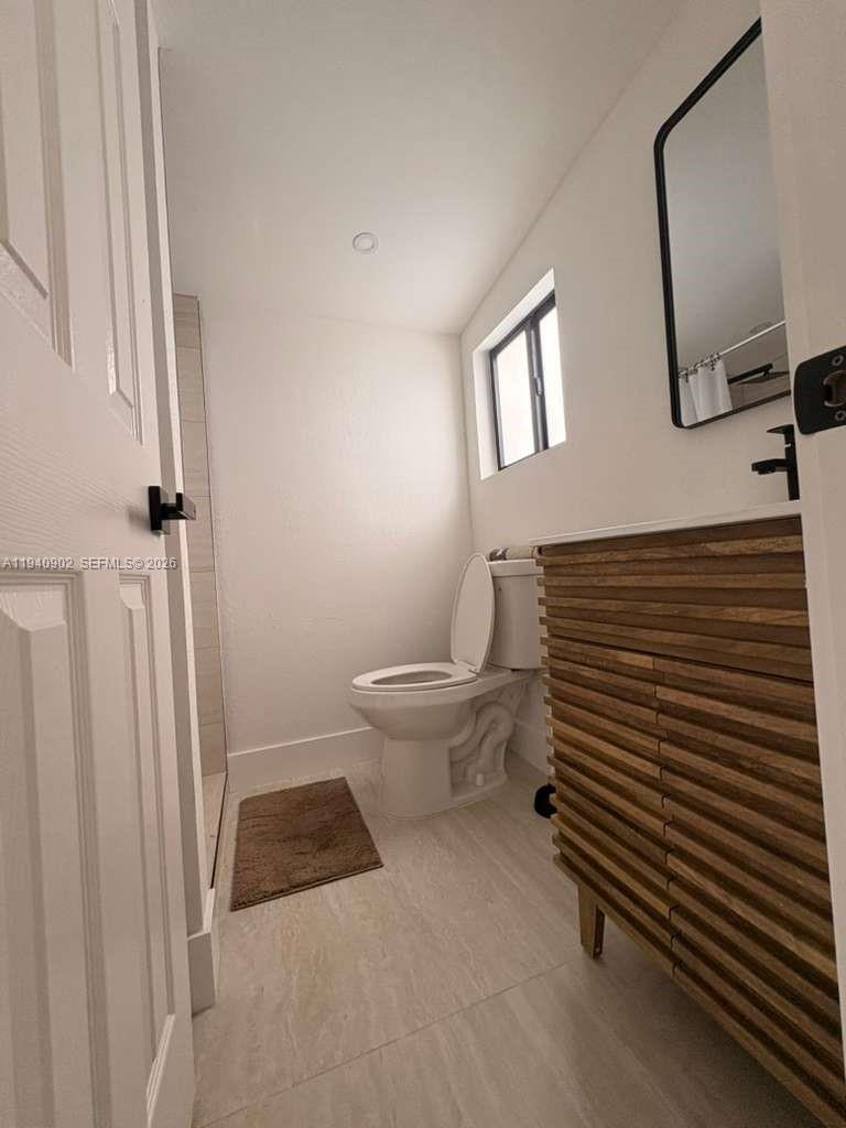 2442 Southwest 3rd Street, Unit 4 Miami, FL 33135 - Photo 8 of 13 a bathroom with a toilet a sink and a window