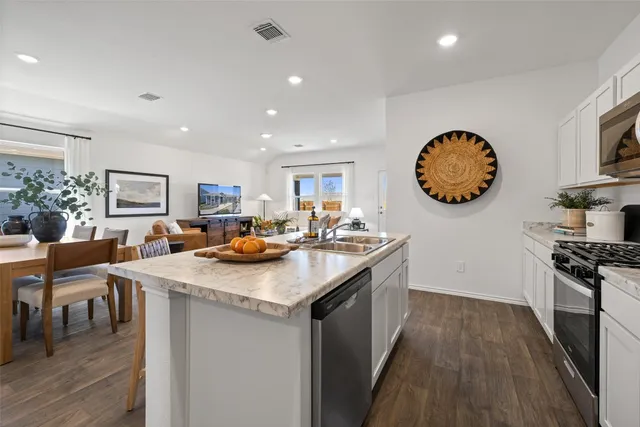 a kitchen with stainless steel appliances granite countertop sink stove and cabinets