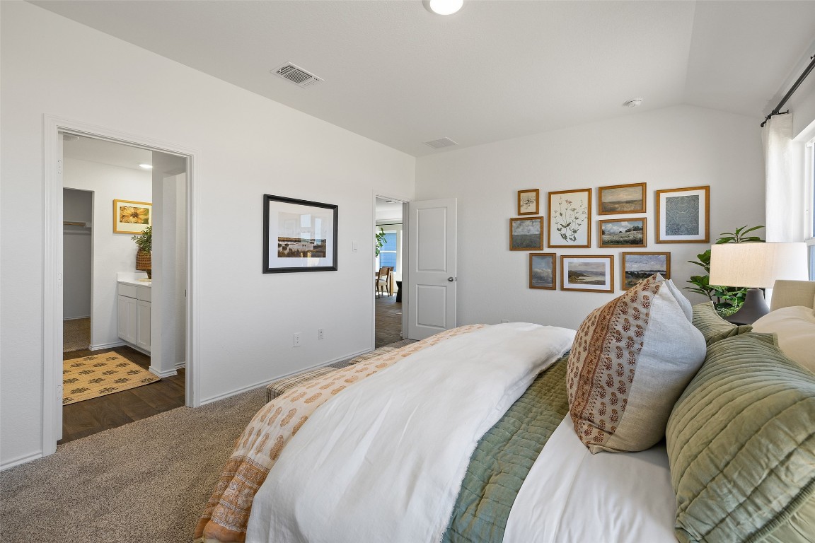 173 Balmorhea Street Kyle, TX 78640 - Photo 18 of 29 a bed room with a bed and a painting on the wall