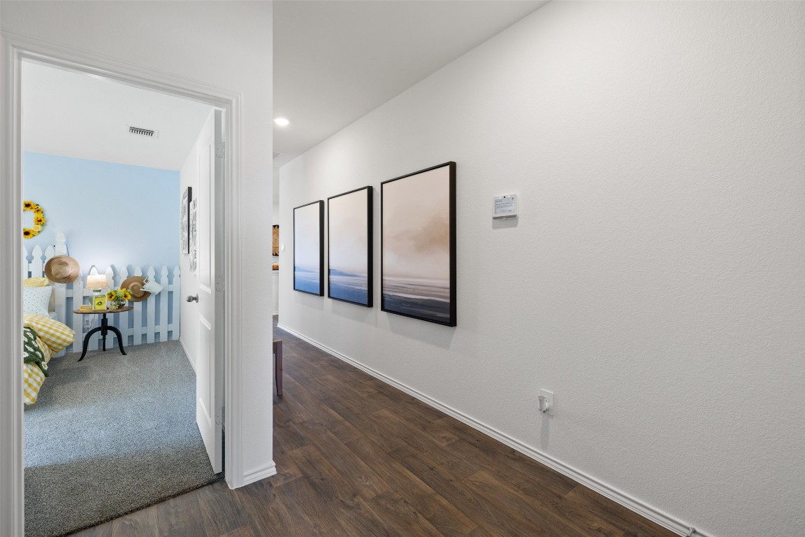 173 Balmorhea Street Kyle, TX 78640 - Photo 21 of 29 a view of a hallway with wooden floor and a dining room