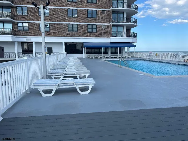 a view of a patio with table and chairs with wooden floor and fence