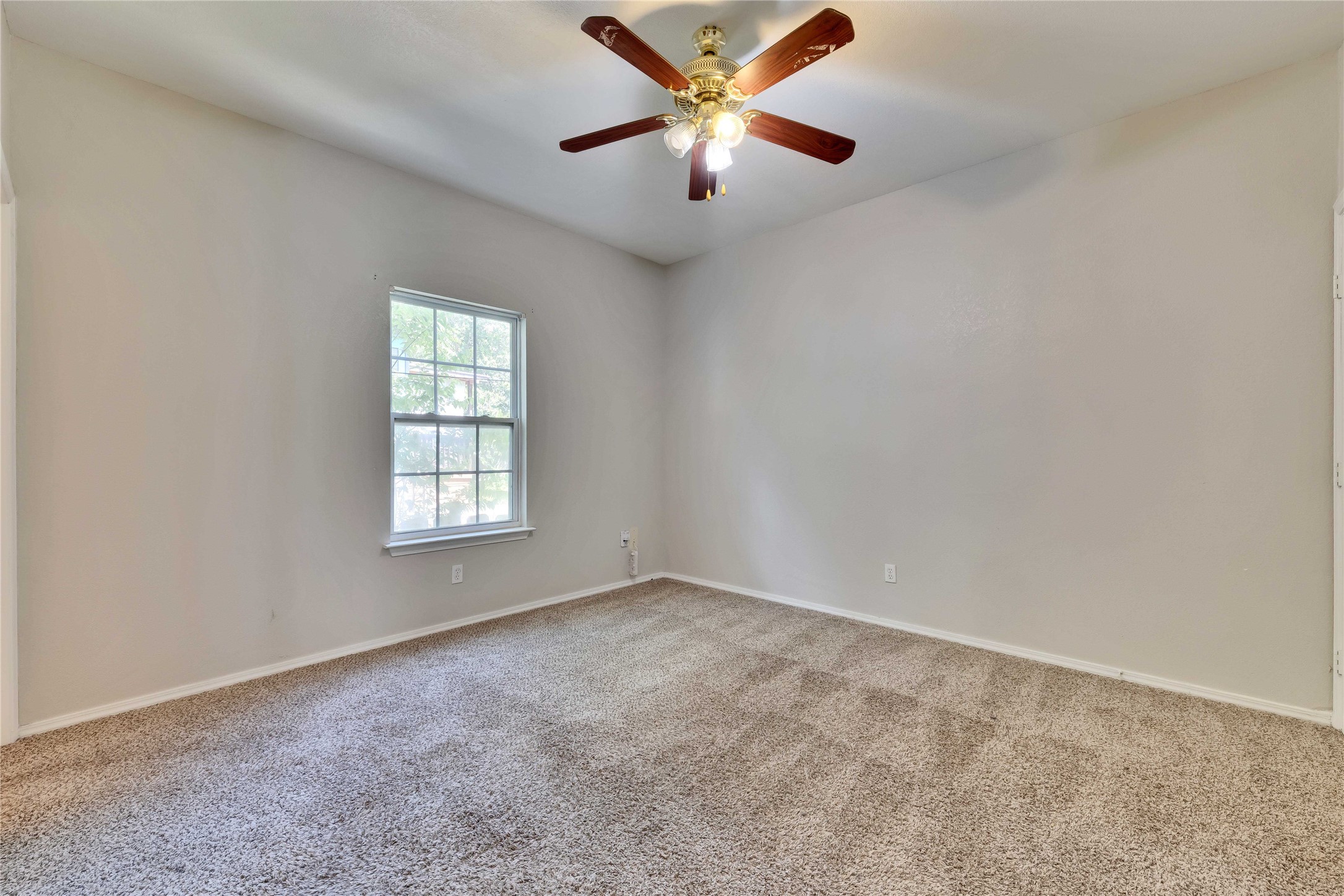 2201 East 18th Street, Unit B Austin, TX 78702 - Photo 10 of 25 Cozy bedroom with textured carpet and an overhead ceiling fan.