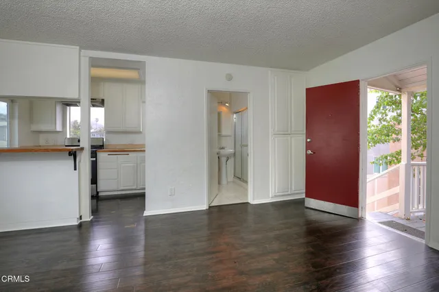 a view of a kitchen with a fridge wooden floor and a window