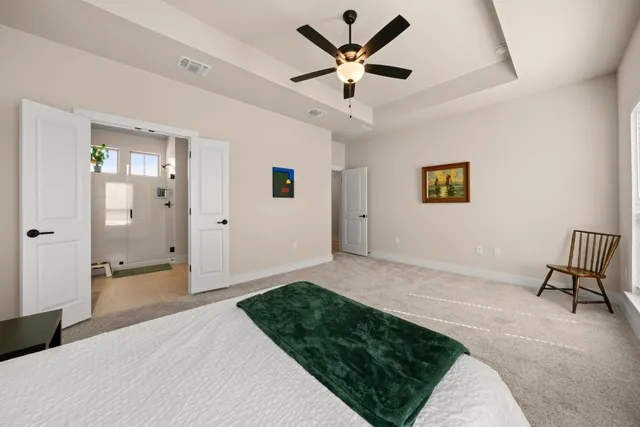 a spacious bedroom with a bed and a chandelier