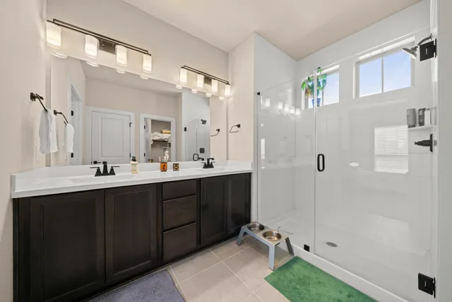 a bathroom with a double vanity sink mirror and shower