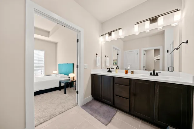 a spacious bathroom with a double vanity sink a mirror and a bathtub