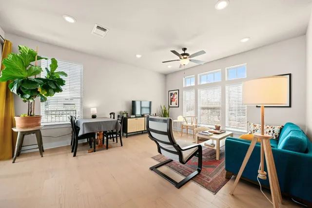 a living room with furniture a dining table and a potted plant