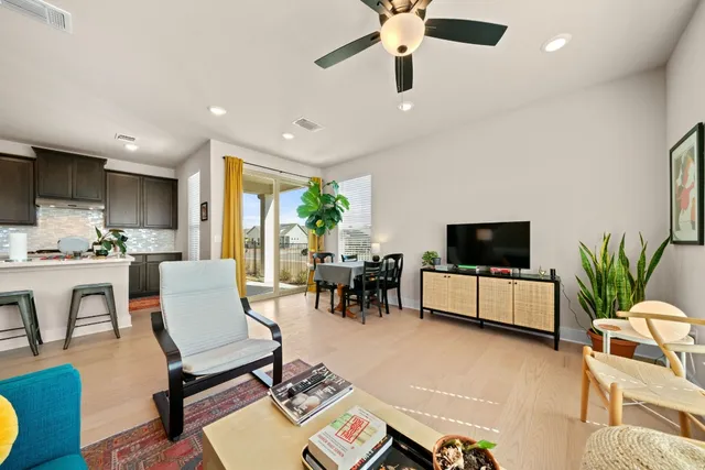 a living room with furniture and a flat screen tv with wooden floor