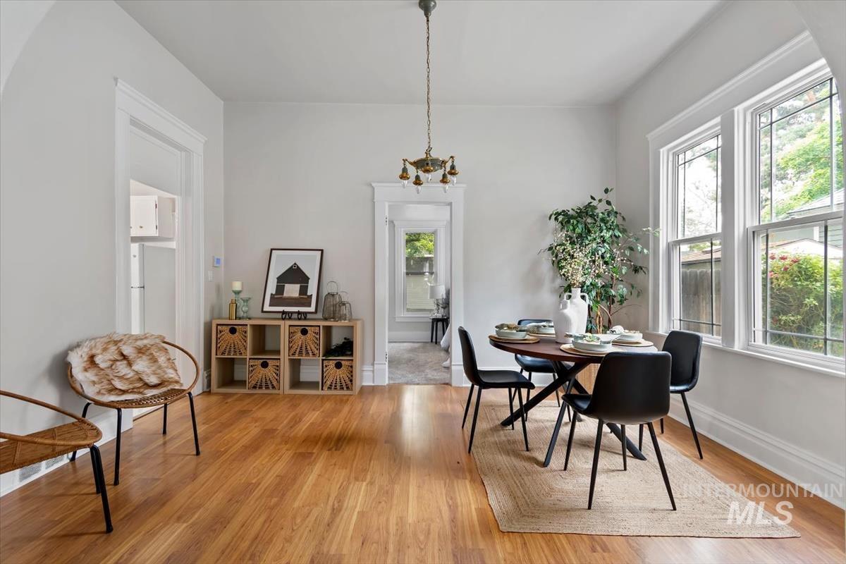910 North 16th Street Boise, ID 83702 - Photo 9 of 47 Spacious interior room featuring wood-finish flooring, a decorative ceiling fixture, and multiple large windows with white trim
