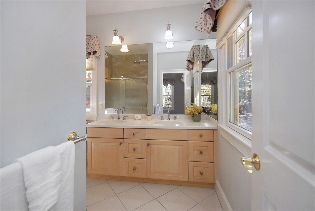 96 Forest Ridge Road, Unit 96 Concord, MA 01742 - Photo 25 of 36 a spacious bathroom with a granite countertop sink a mirror and a shower