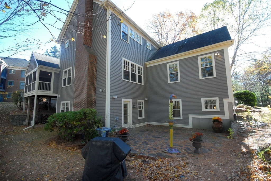96 Forest Ridge Road, Unit 96 Concord, MA 01742 - Photo 30 of 36 a backyard of a house with barbeque oven fire pit table and chairs