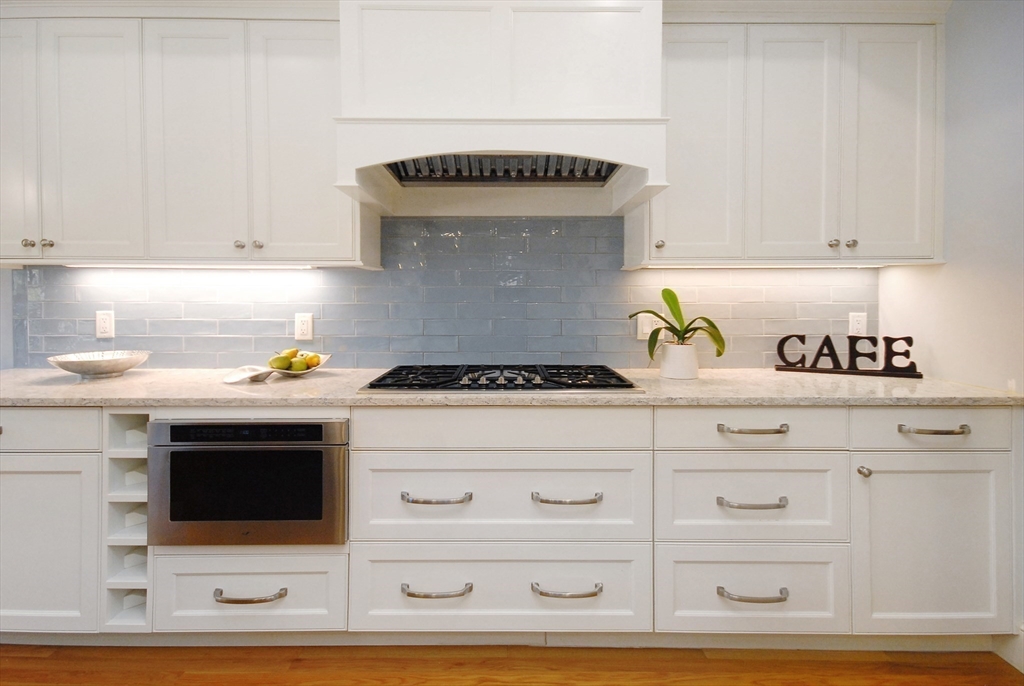 96 Forest Ridge Road, Unit 96 Concord, MA 01742 - Photo 7 of 36 a kitchen with a stove and a white cabinets
