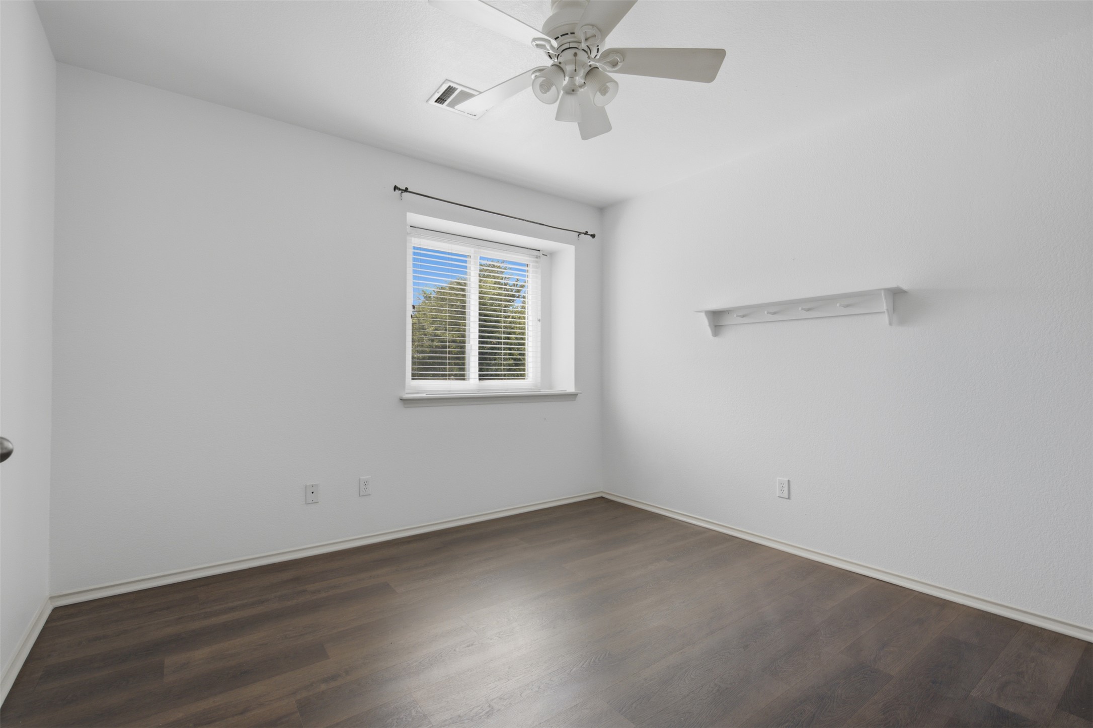 1416 Roxanne's Run Pflugerville, TX 78660 - Photo 23 of 35 A quiet bedroom features wood flooring, a window with blinds, and a practical ceiling fan.