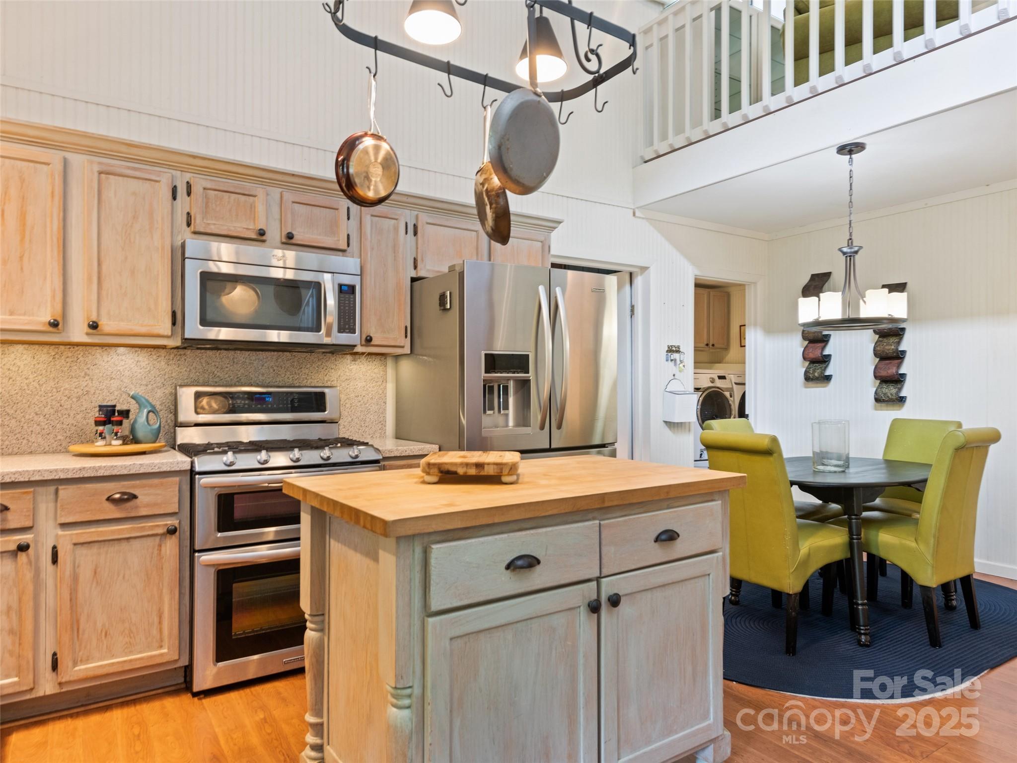 195 Three Springs Drive Sylva, NC 28779 - Photo 23 of 48 a kitchen with stainless steel appliances granite countertop a stove a sink dishwasher and white cabinets with wooden floor