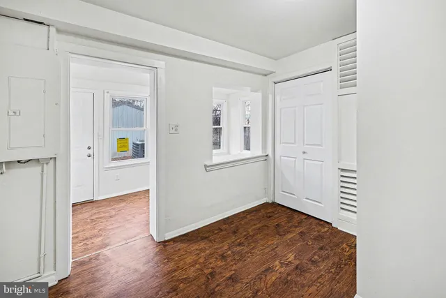 a view of a hallway with wooden floor and closet