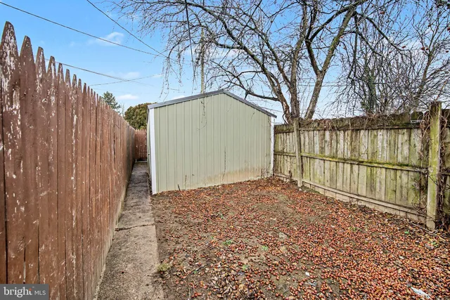 a view of backyard with wooden fence and large trees