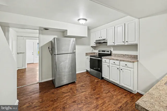 a kitchen with white cabinets and stainless steel appliances