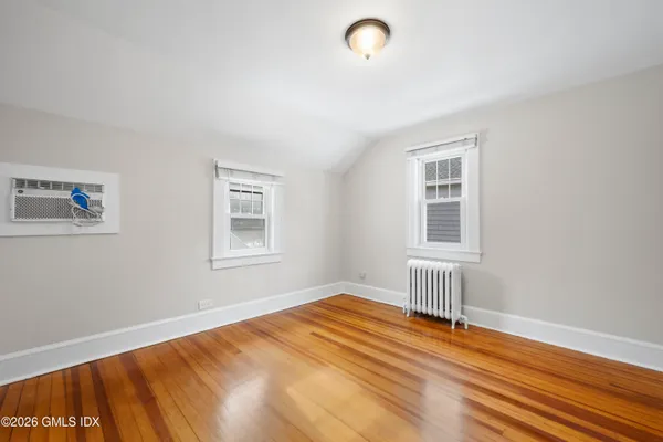 a view of empty room with wooden floor