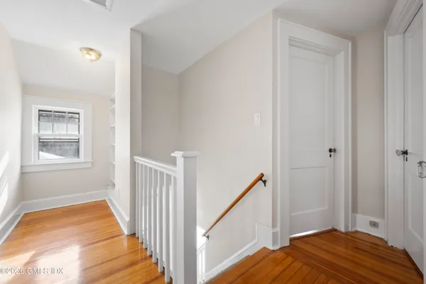 a view of a bedroom with wooden floor and staircase