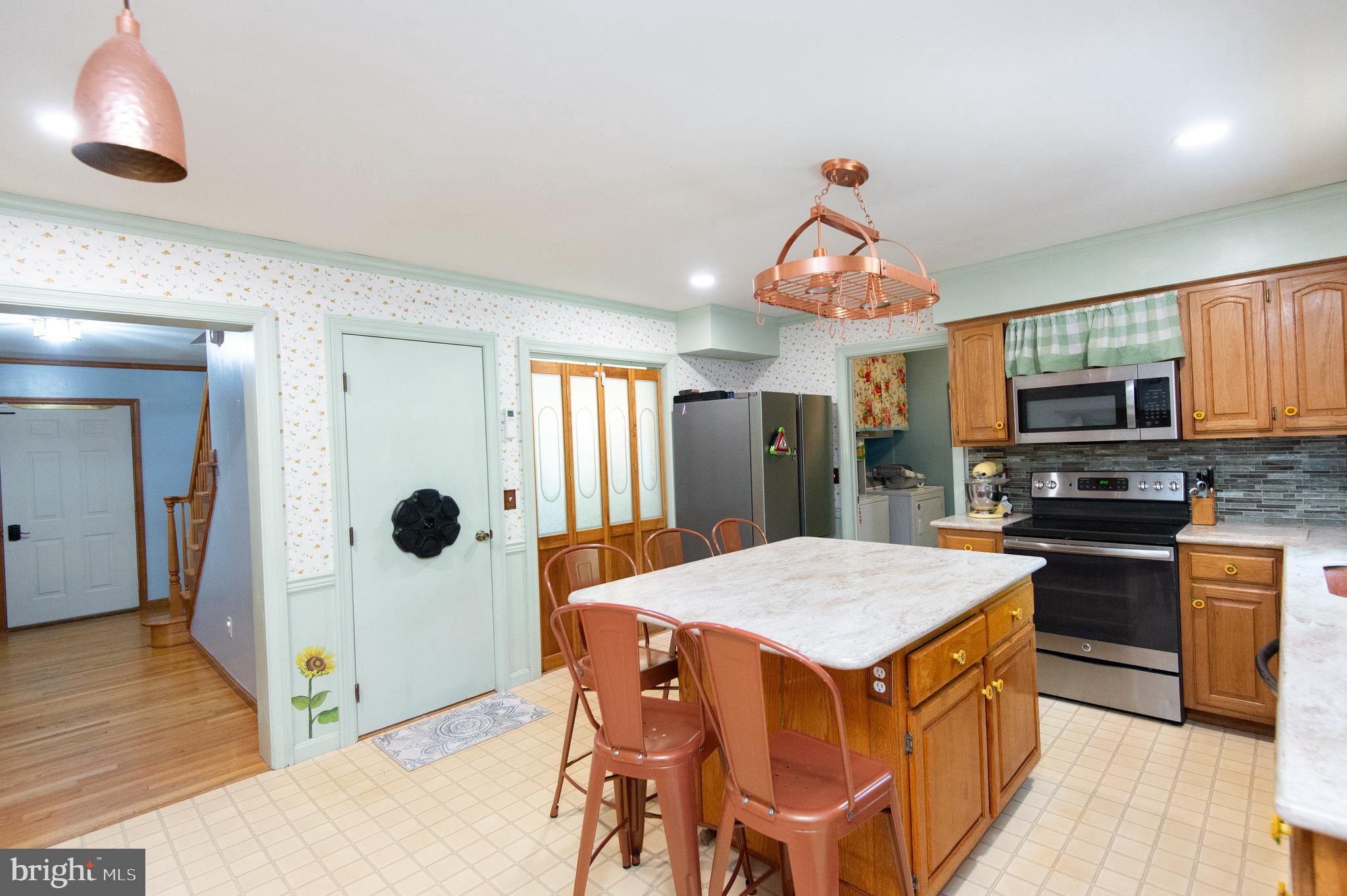 9472 Quail Run Road Denton, MD 21629 - Photo 5 of 50 a kitchen with stainless steel appliances wooden floor dining table and chairs