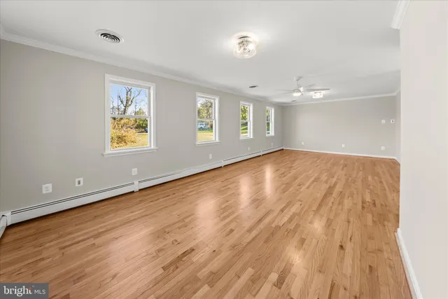a view of empty room with wooden floor