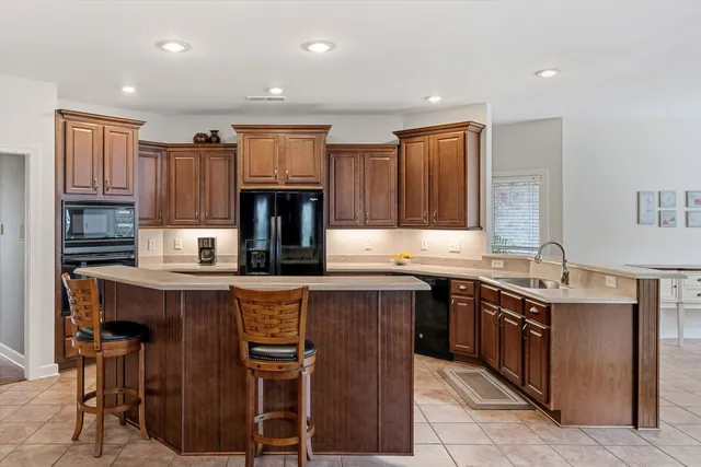 a kitchen with kitchen island granite countertop a sink counter top space stainless steel appliances and cabinets