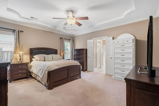 a bedroom with a bed a dresser and a chandelier