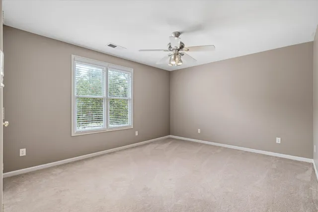 an empty room with a window and a fan