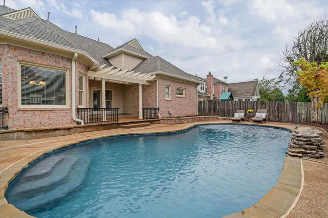 a view of a house with swimming pool and sitting area