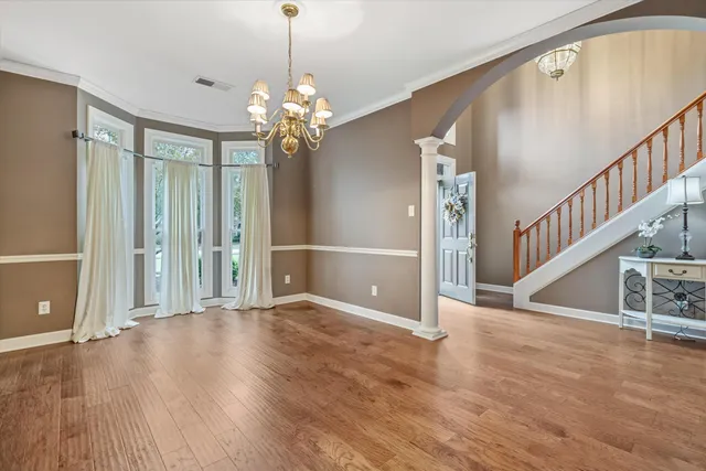 a view of a livingroom with wooden floor and stairs