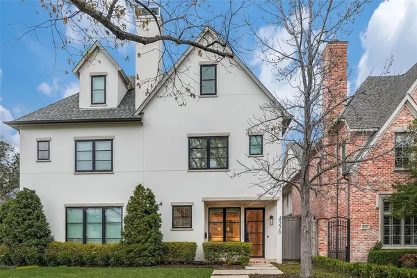 a view of a white house next to a yard