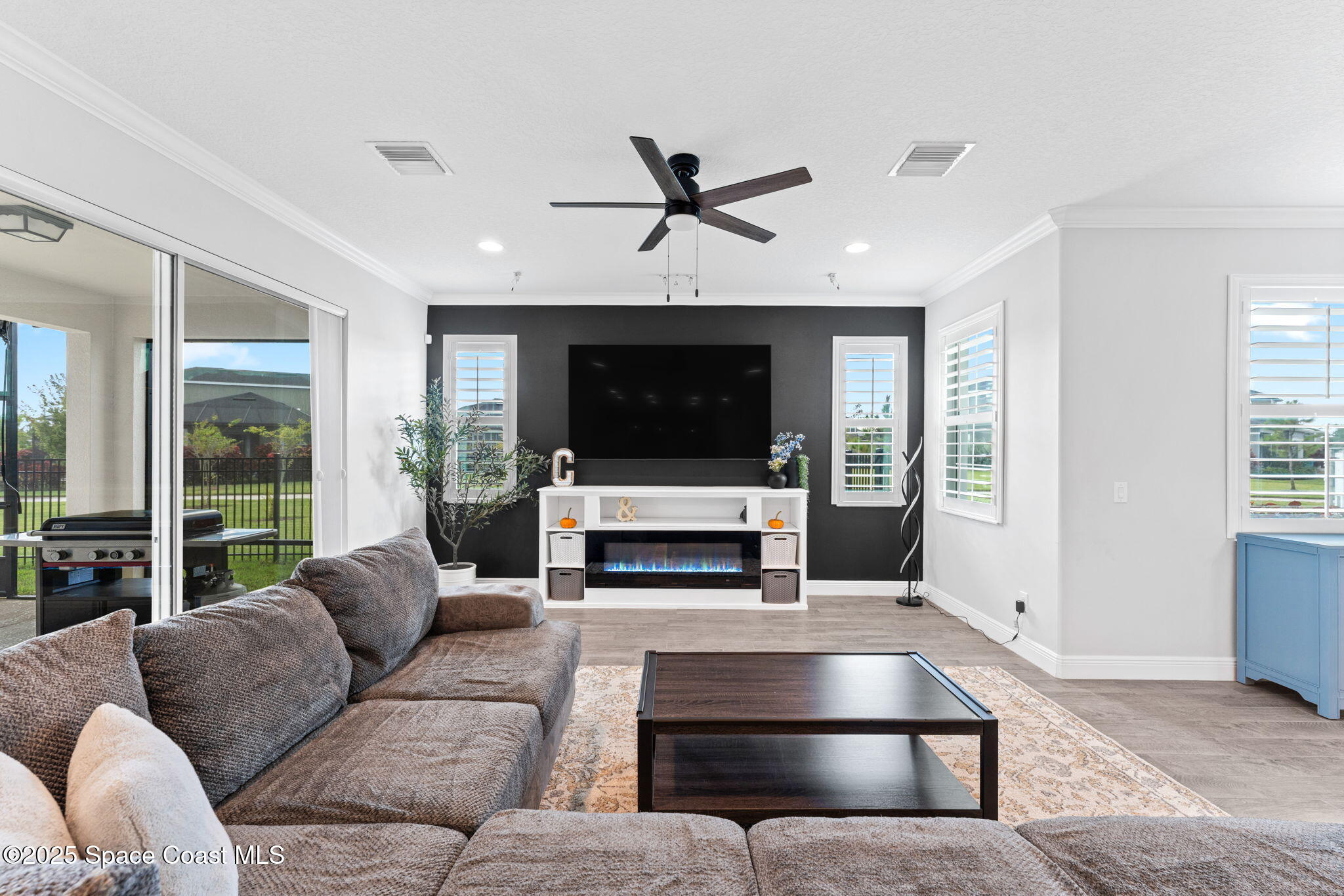 8215 Millbrook Avenue Melbourne, FL 32940 - Photo 10 of 62 a living room with furniture and a flat screen tv