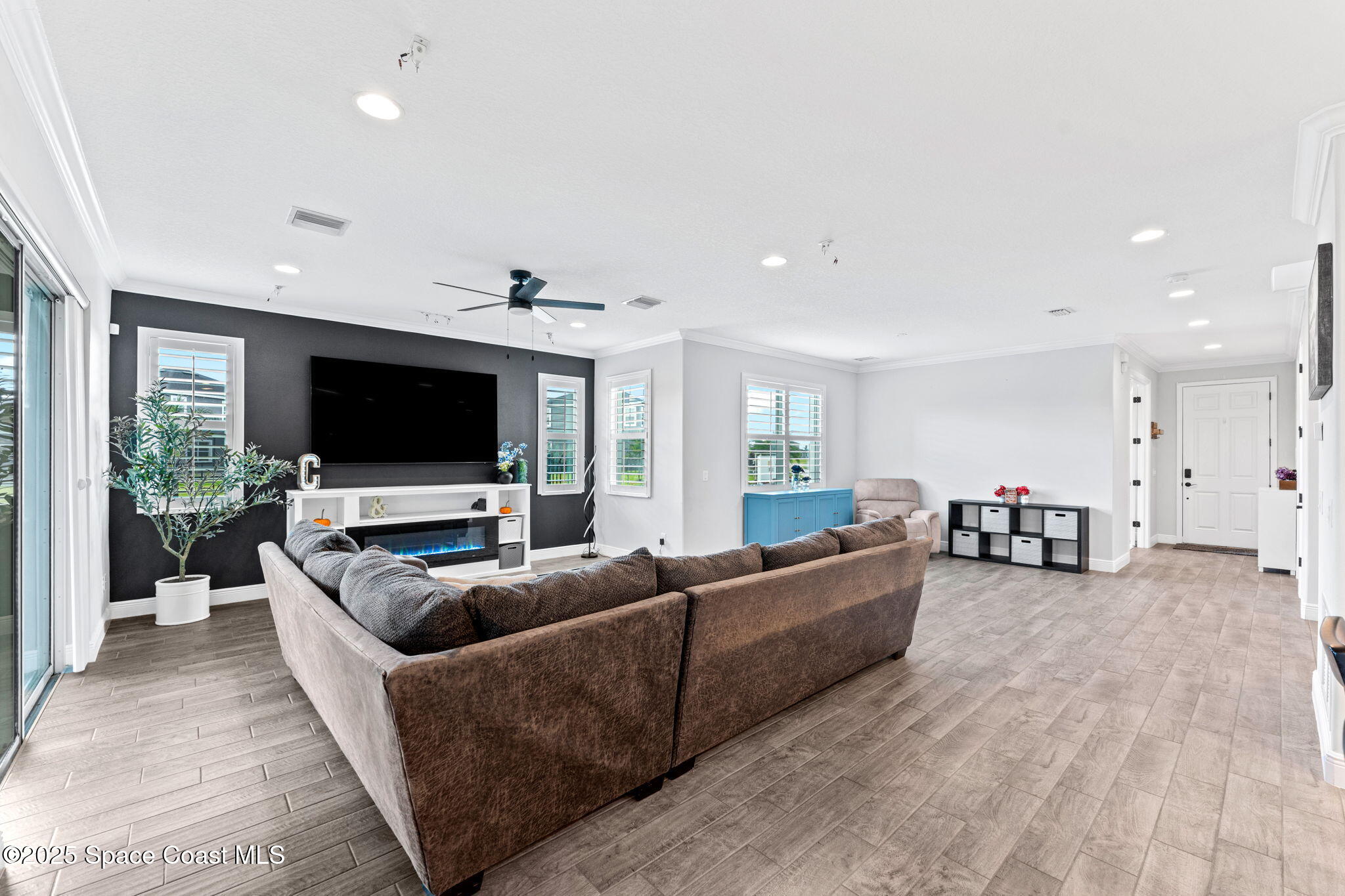 8215 Millbrook Avenue Melbourne, FL 32940 - Photo 11 of 62 a living room with furniture and a flat screen tv