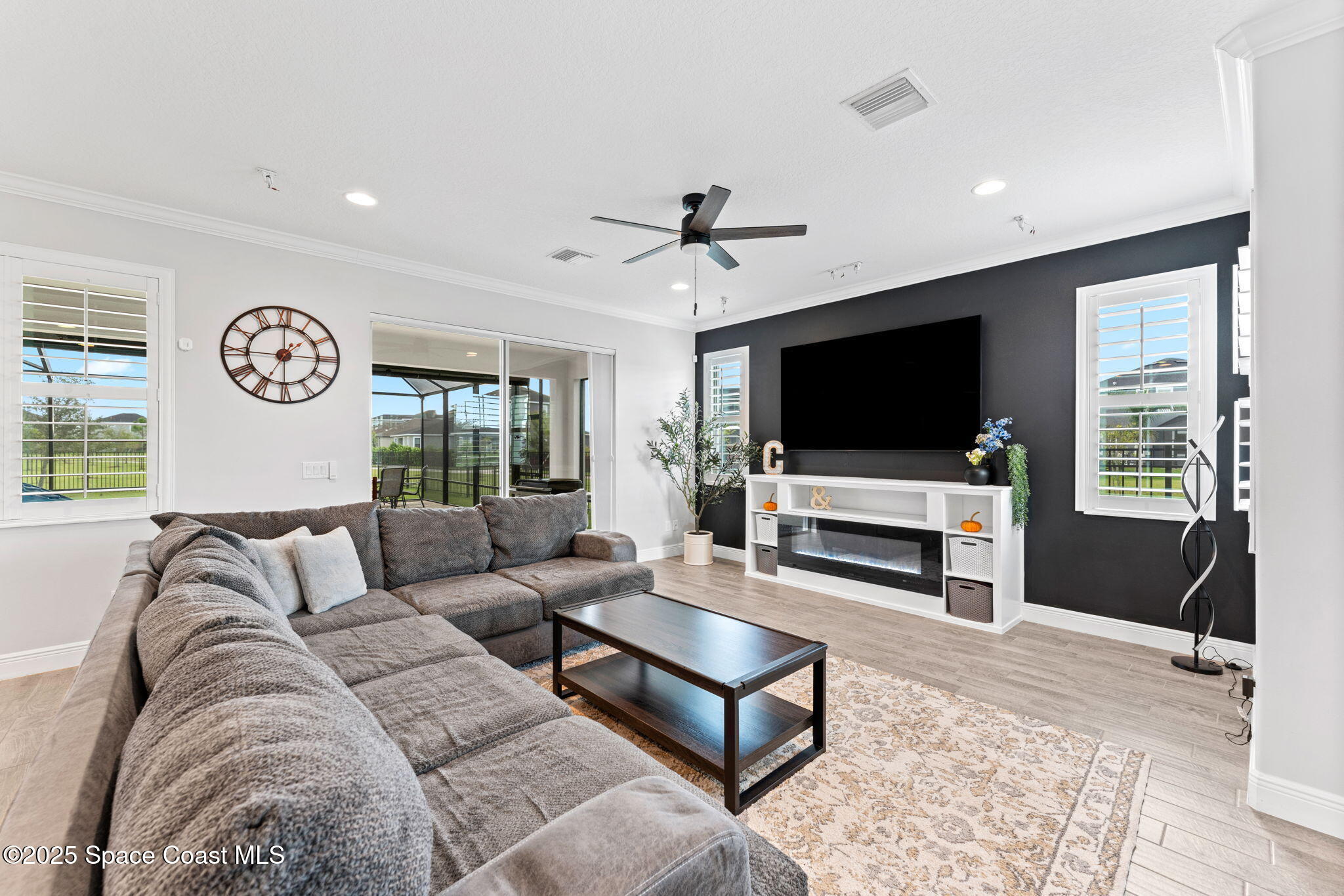 8215 Millbrook Avenue Melbourne, FL 32940 - Photo 12 of 62 a living room with furniture and a flat screen tv