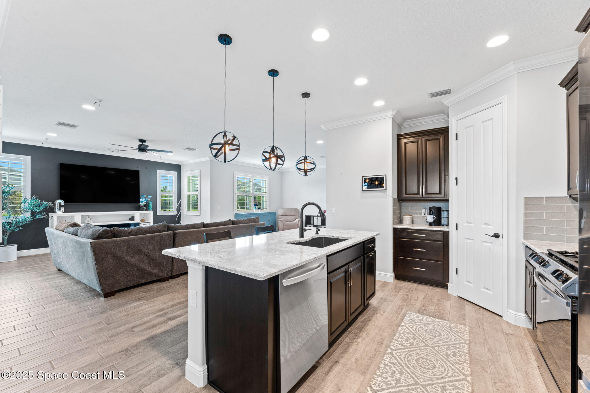 8215 Millbrook Avenue Melbourne, FL 32940 - Photo 17 of 62 a large kitchen with stainless steel appliances granite countertop a stove a sink and a refrigerator