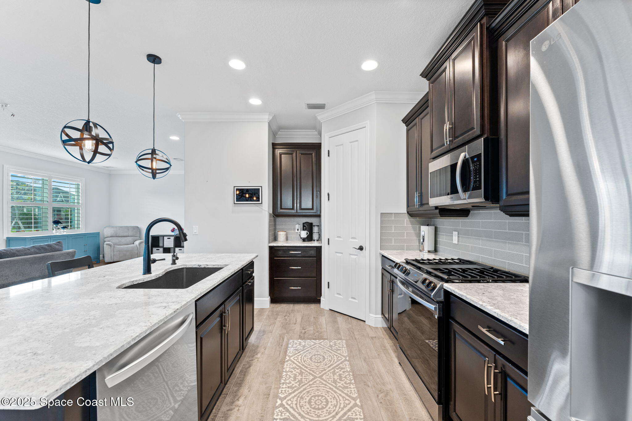 8215 Millbrook Avenue Melbourne, FL 32940 - Photo 18 of 62 a kitchen with stainless steel appliances granite countertop a sink a stove and a refrigerator