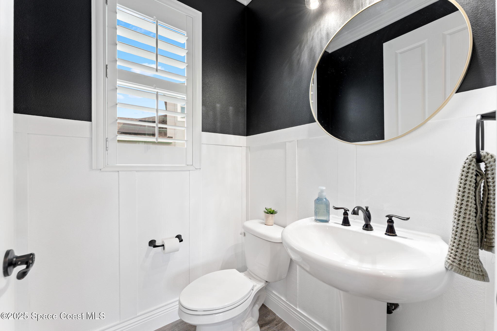 8215 Millbrook Avenue Melbourne, FL 32940 - Photo 22 of 62 a white toilet sitting next to a bathroom sink