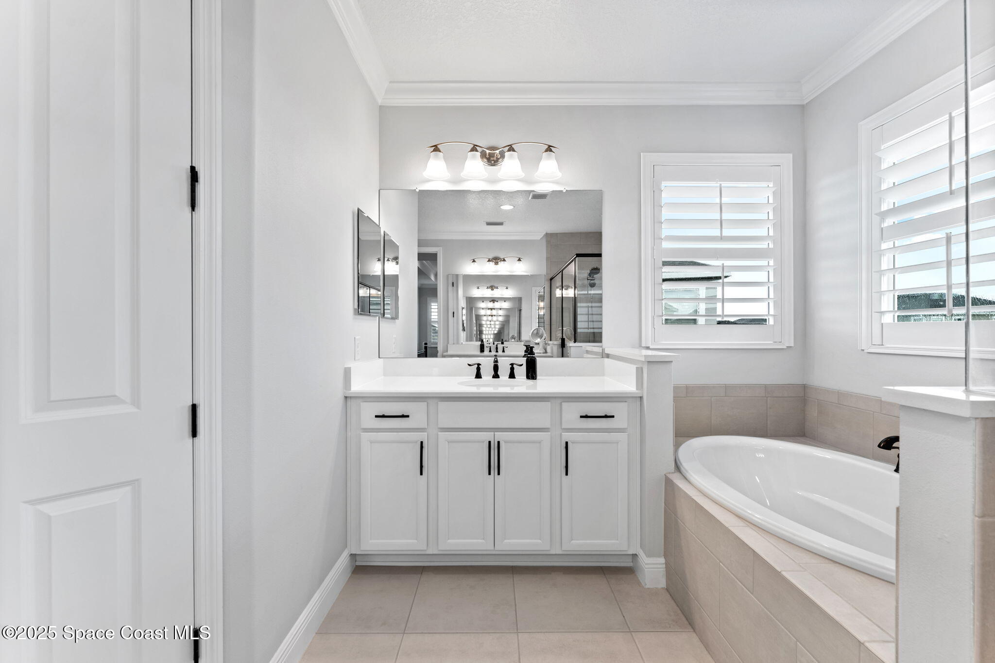 8215 Millbrook Avenue Melbourne, FL 32940 - Photo 28 of 62 a bathroom with a tub sink and mirror