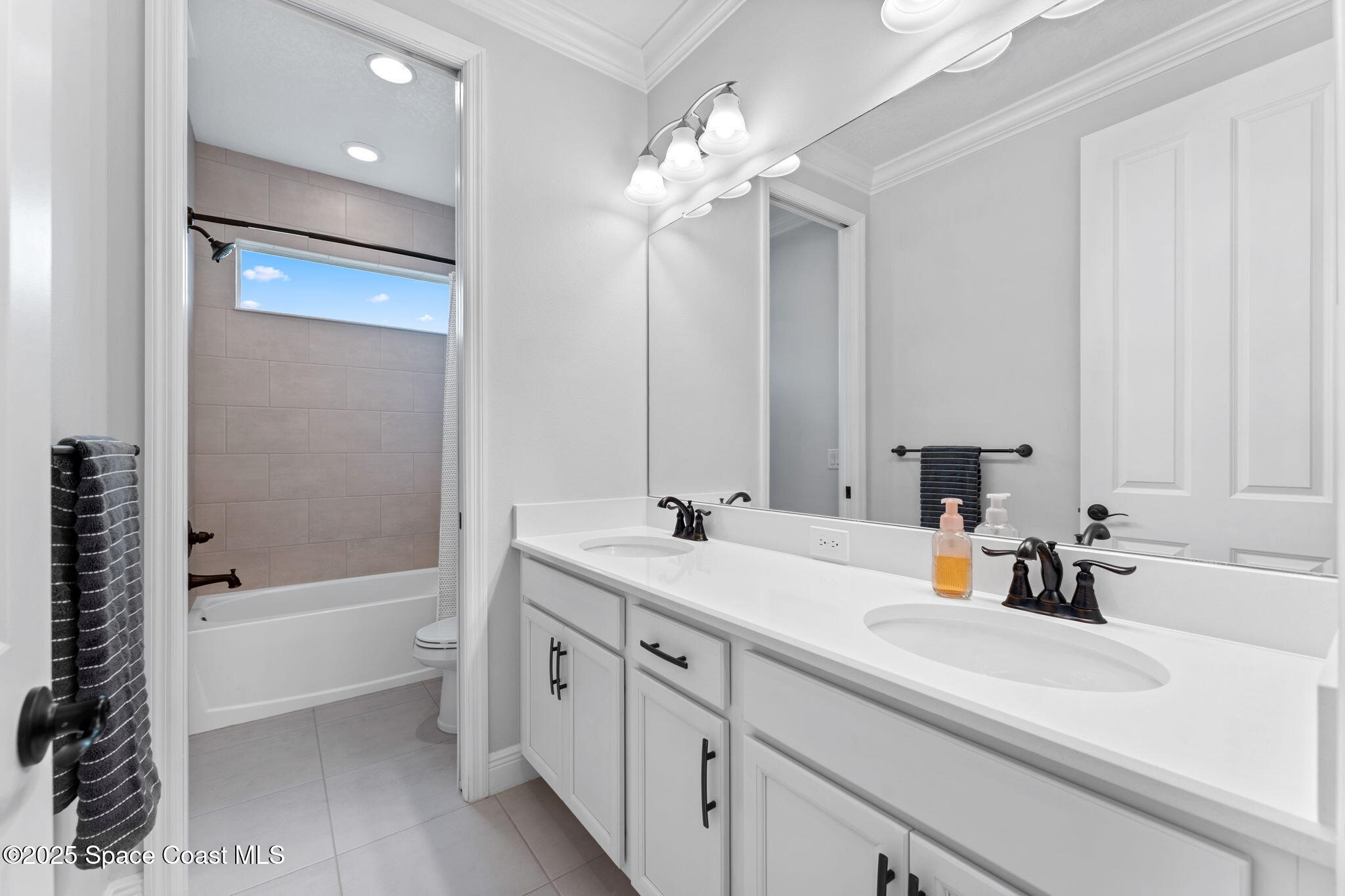 8215 Millbrook Avenue Melbourne, FL 32940 - Photo 31 of 62 a bathroom with a tub a sink and mirror